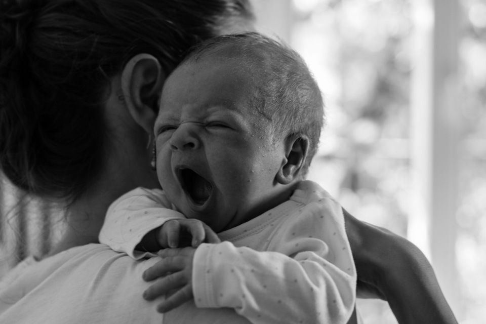 Baby gähnt genüssliich auf der Schulter der Mama.