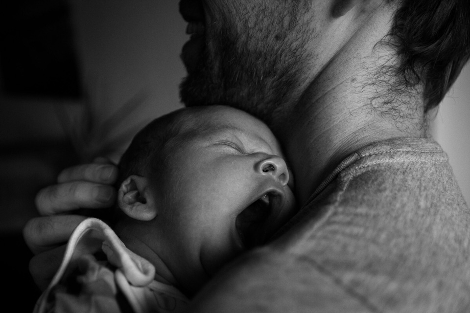 Baby gähnt auf der Schulter des Papas.